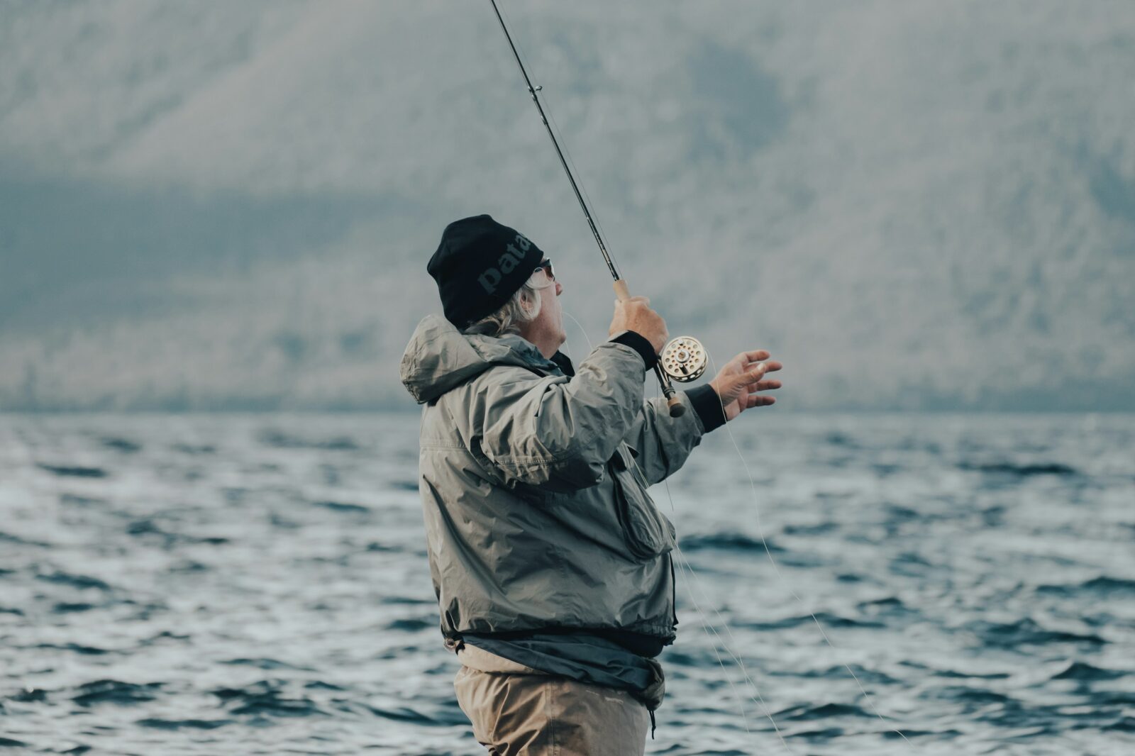 a man standing on a boat holding a fishing rod
