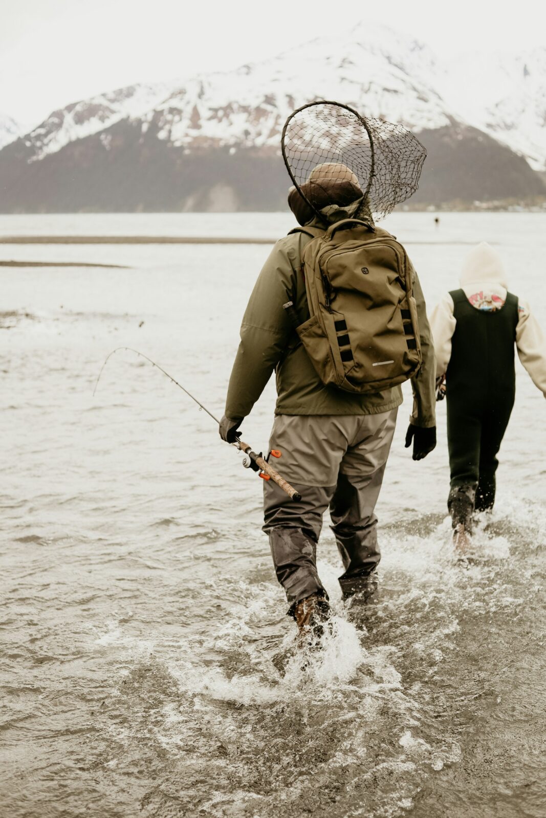A couple of people walking across a river